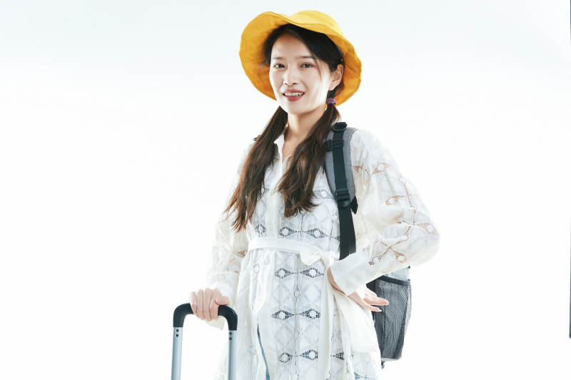 白色背景下准备出发旅行的美丽东方女大学生图片