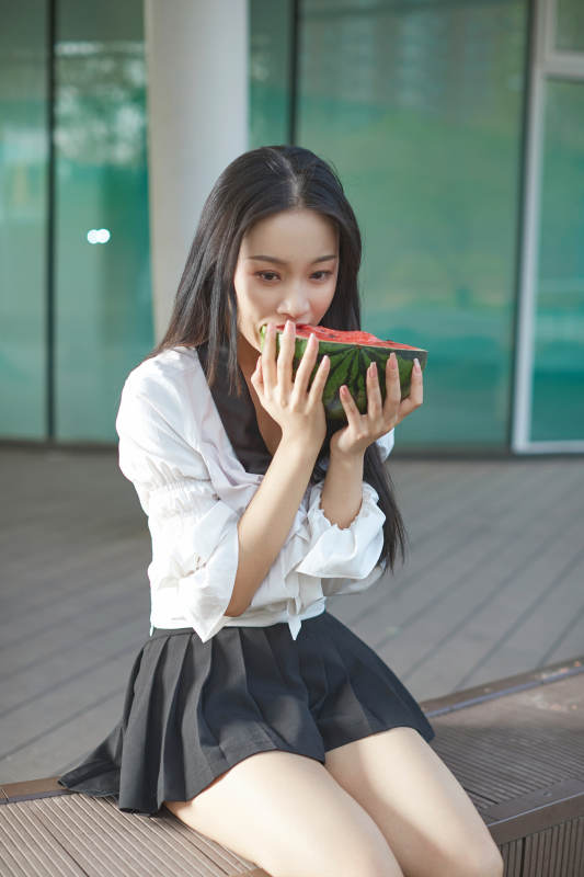 初夏户外公园吃西瓜的可爱少女图片