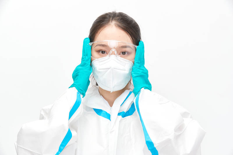 穿白色防护服佩戴护目镜口罩的女性医疗人员图片