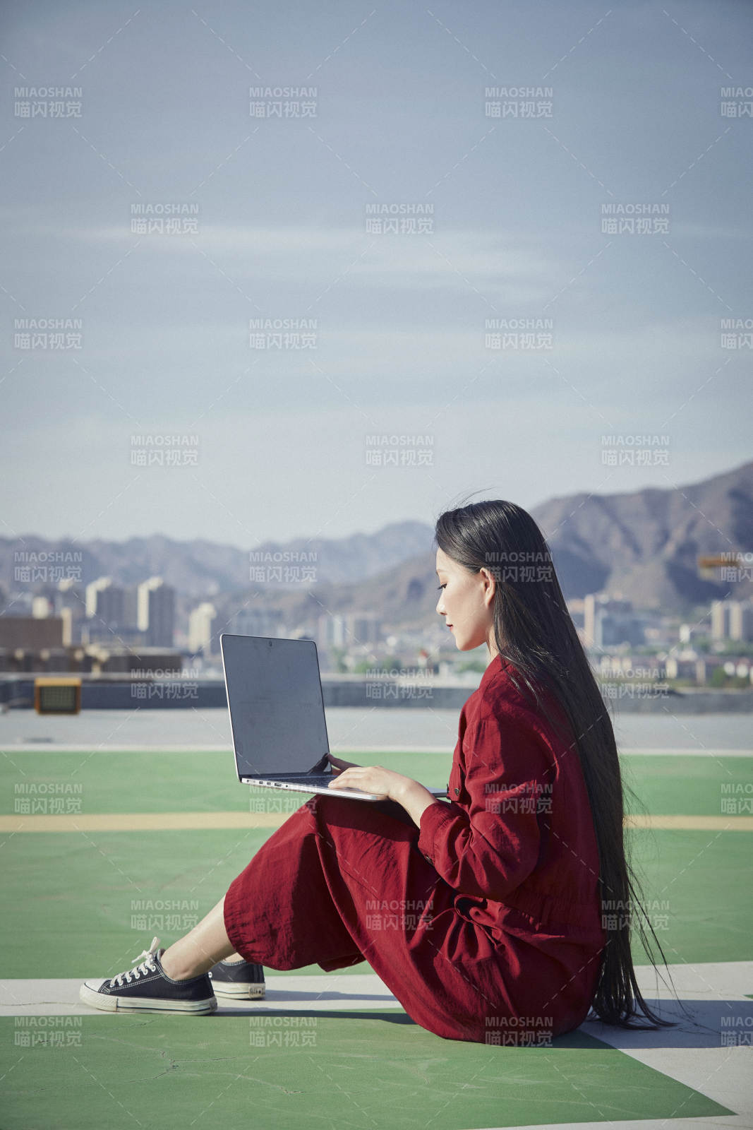 亚洲商务年轻女性在楼顶停机坪使用电脑办公图片