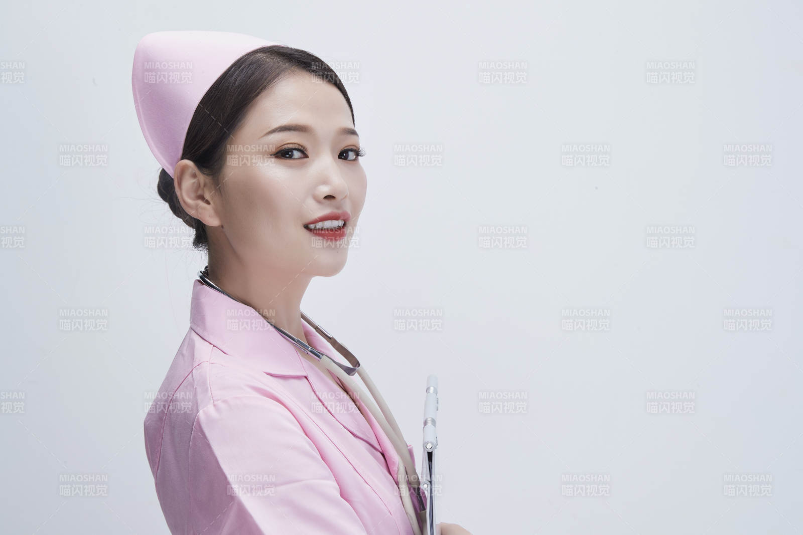 穿粉色护士服戴听诊器手持病历夹的医护人员图片