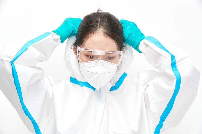 穿白色防护服佩戴护目镜口罩的女性医疗人员图片