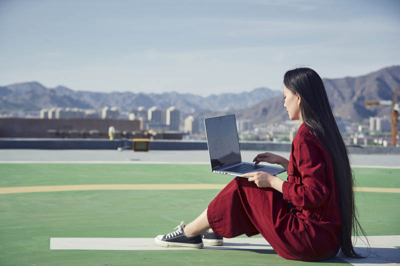 亚洲商务年轻女性在楼顶停机坪使用电脑办公图片