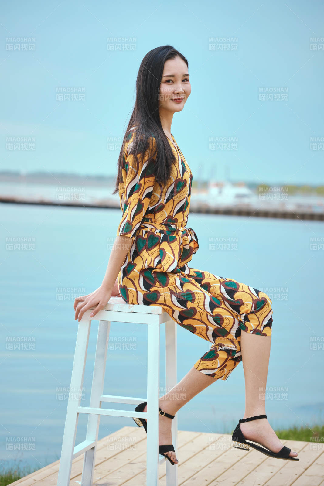 悠闲的坐在美丽湖岸码头的亚洲年轻女性人像图片