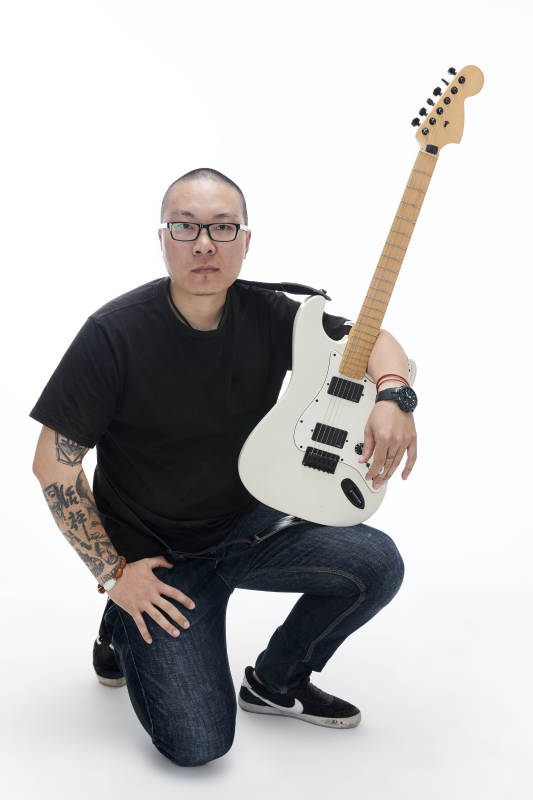 手持电吉他展示演奏的亚洲男性摇滚乐手人像图片