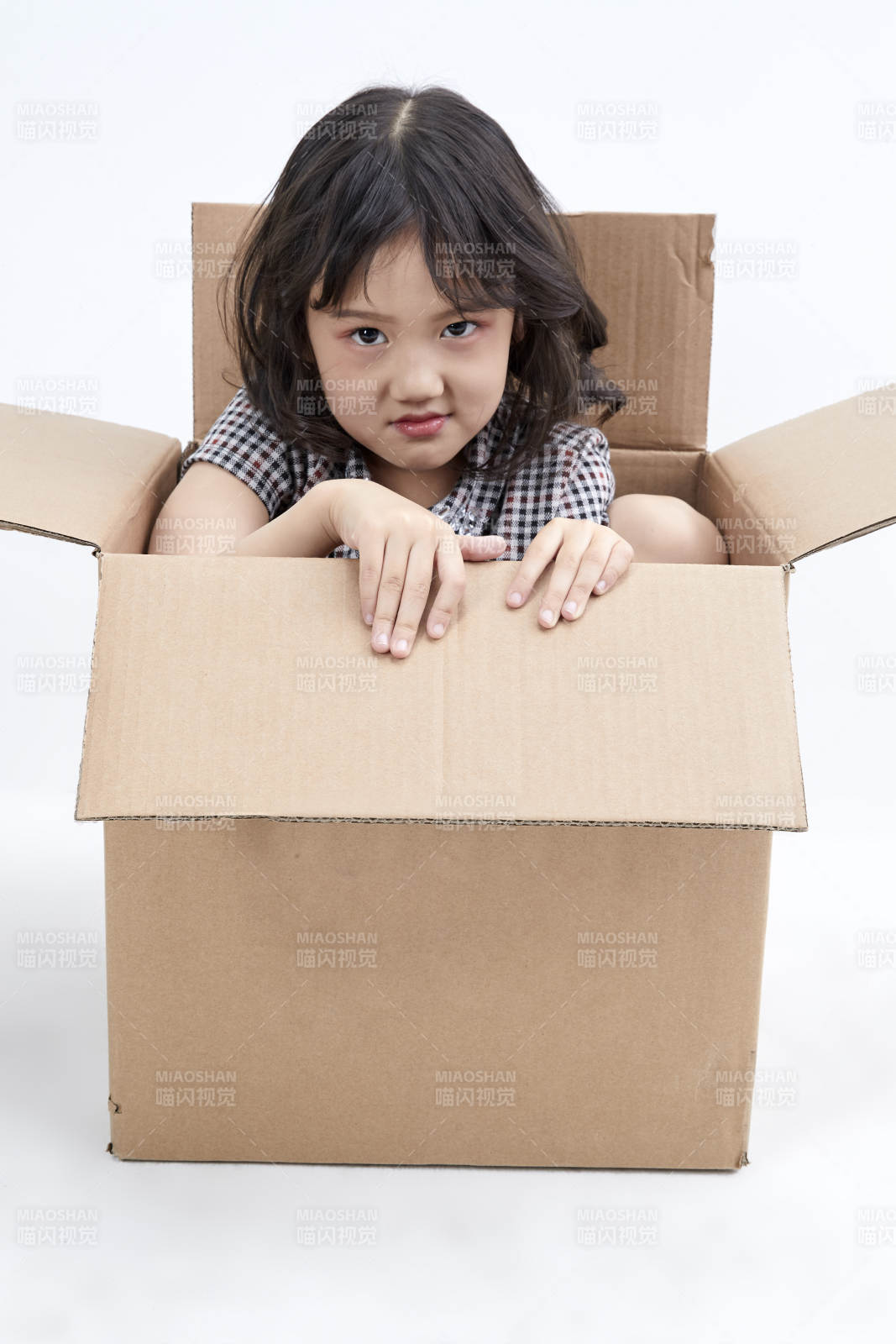 躲在纸箱中玩耍的调皮可爱亚洲小女孩儿童图片