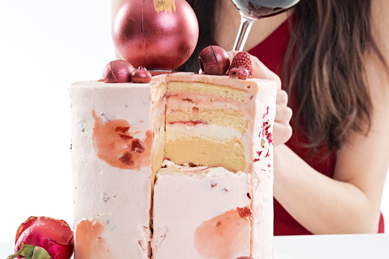 喝红酒品尝蛋糕的年轻女性图片