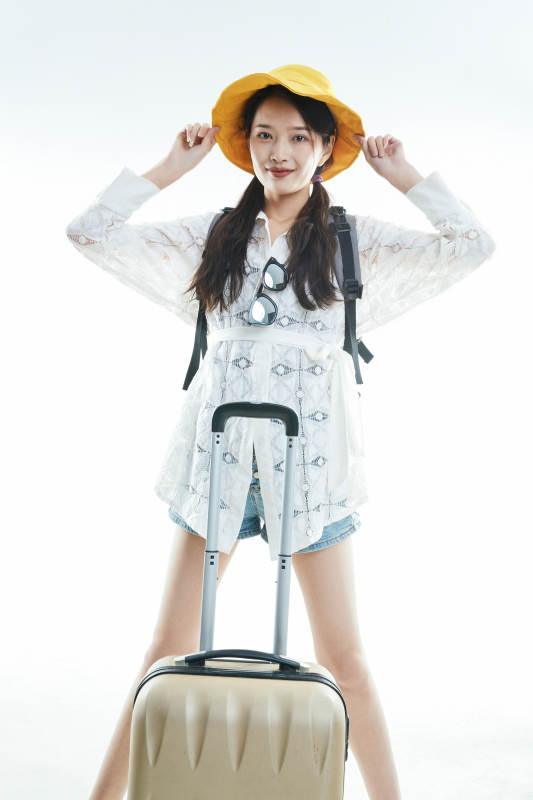 白色背景下准备出发旅行的美丽东方女大学生图片