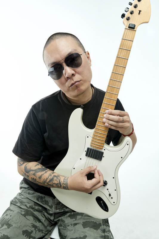 手持电吉他展示演奏的亚洲男性摇滚乐手人像图片