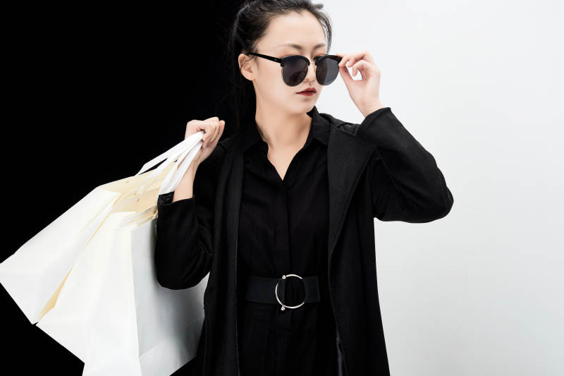 黑白色背景下的手提购物袋的时尚亚洲少女图片