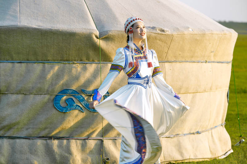 草原上穿着蒙古族传统服饰的亚洲年轻美少女图片