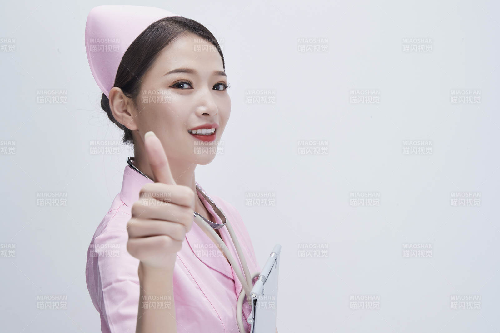 穿粉色护士服戴听诊器手持病历夹的医护人员图片