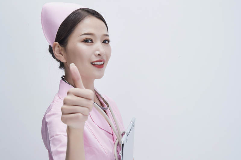 穿粉色护士服戴听诊器手持病历夹的医护人员图片