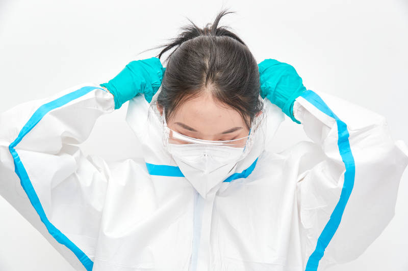穿白色防护服佩戴护目镜口罩的女性医疗人员图片