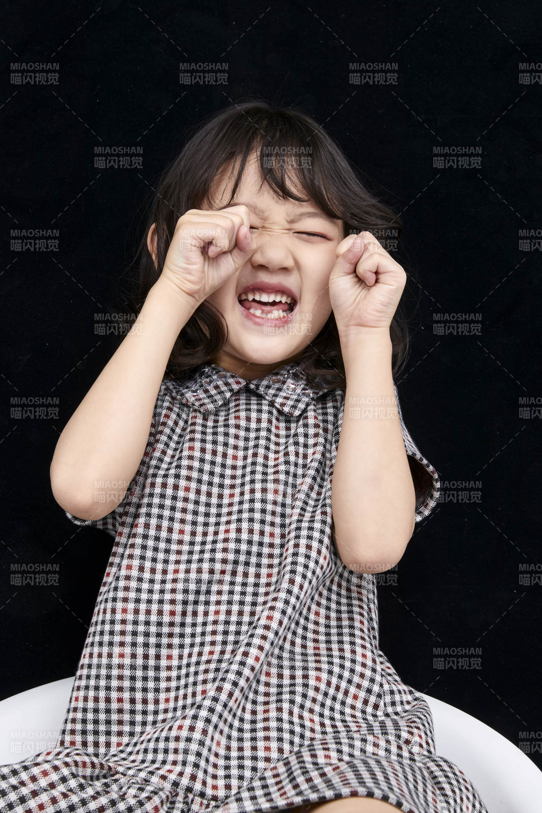 黑色背景里坐在凳子上的可爱的亚洲小女孩儿童图片