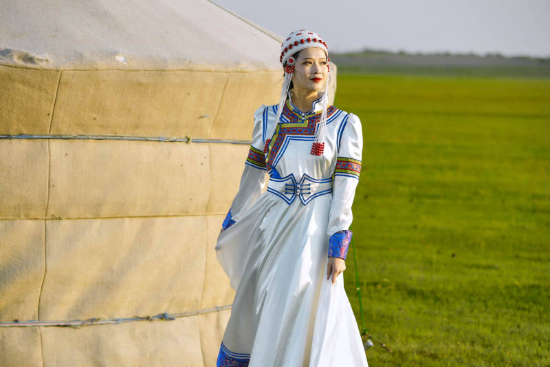 草原上穿着蒙古族传统服饰的亚洲年轻美少女图片