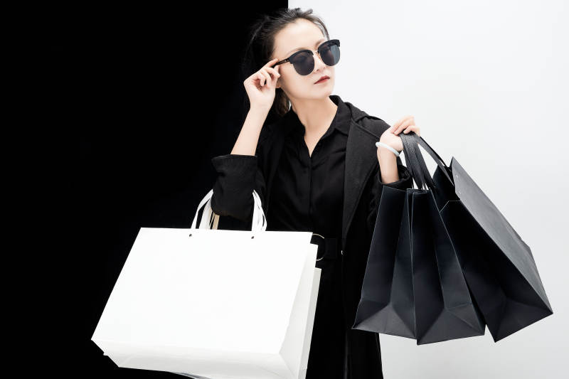 黑白色背景下的手提购物袋的时尚亚洲少女图片