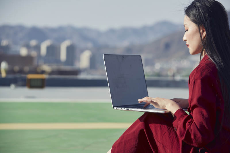 亚洲商务年轻女性在楼顶停机坪使用电脑办公图片