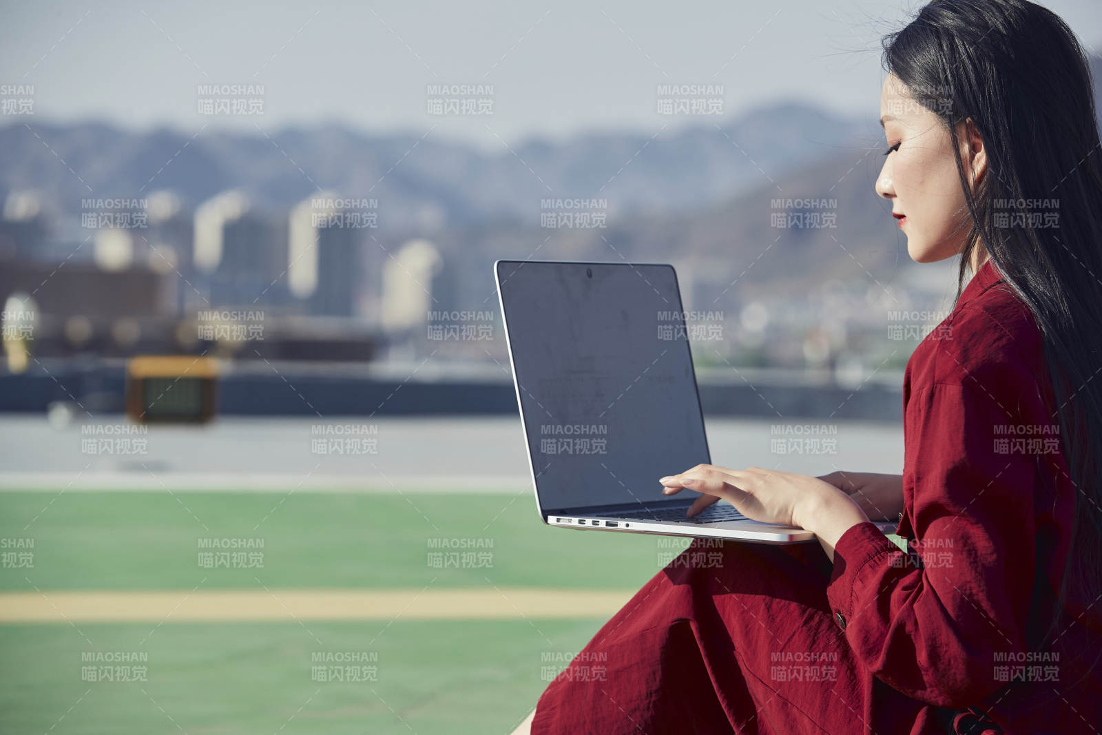 亚洲商务年轻女性在楼顶停机坪使用电脑办公图片