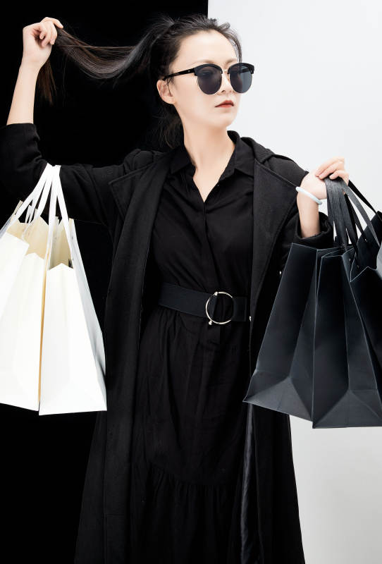 黑白色背景下的手提购物袋的时尚亚洲少女图片