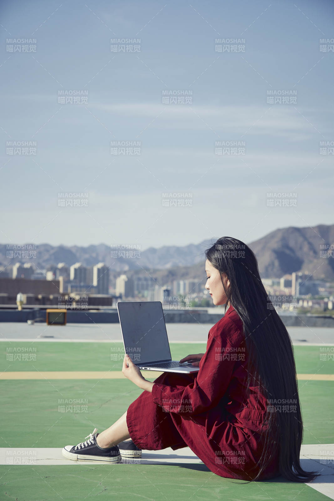 亚洲商务年轻女性在楼顶停机坪使用电脑办公图片