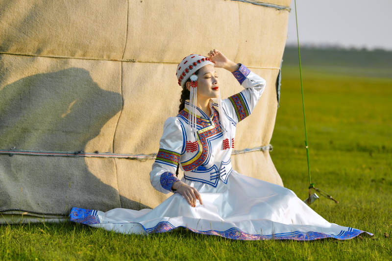 草原上穿着蒙古族传统服饰的亚洲年轻美少女图片