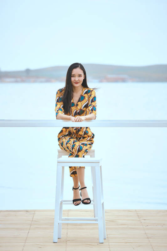 悠闲的坐在美丽湖岸码头的亚洲年轻女性人像图片