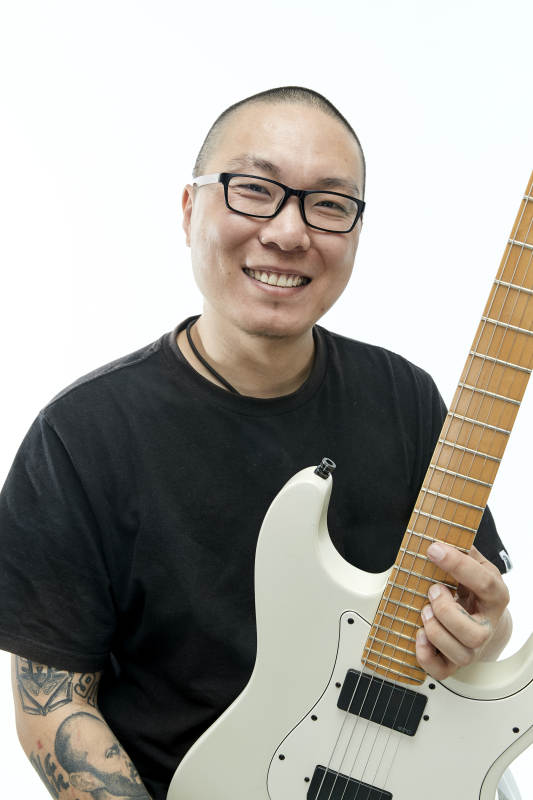 手持电吉他展示演奏的亚洲男性摇滚乐手人像图片