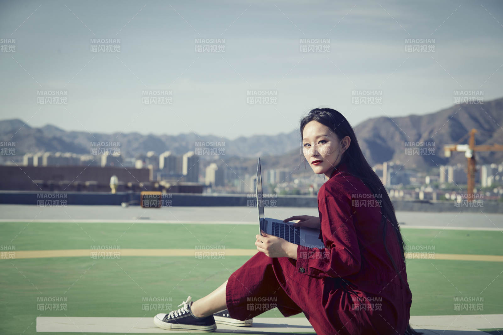 亚洲商务年轻女性在楼顶停机坪使用电脑办公图片