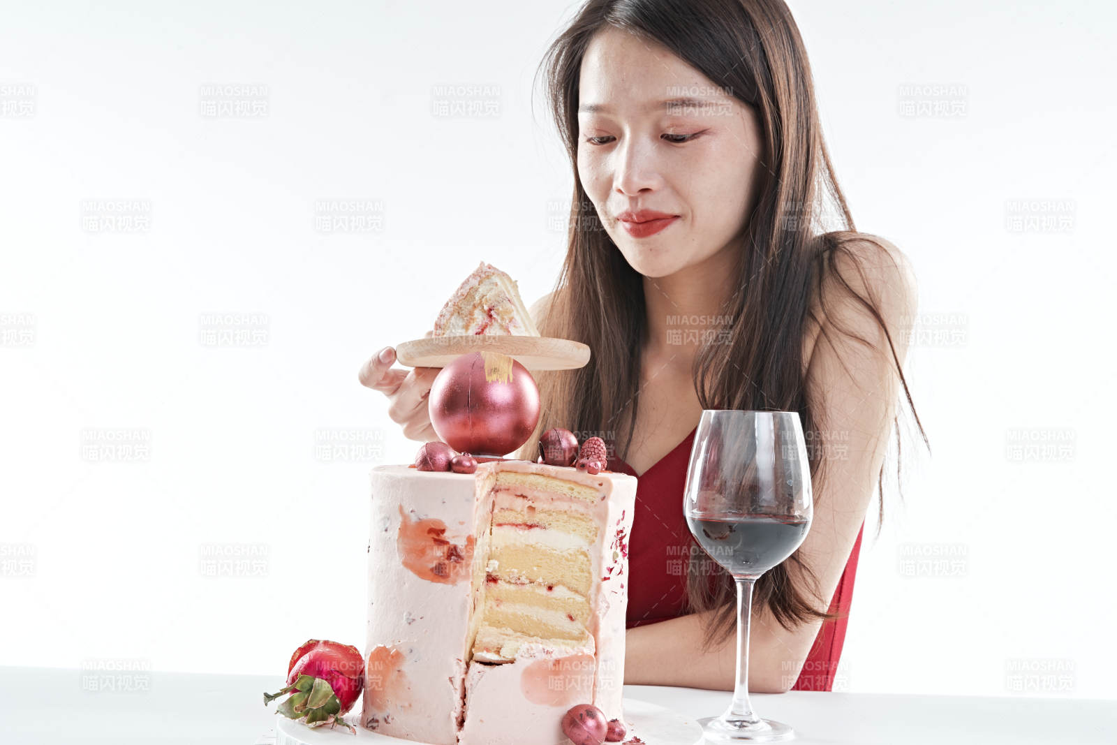 喝红酒品尝蛋糕的年轻女性图片