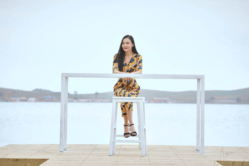 悠闲的坐在美丽湖岸码头的亚洲年轻女性人像图片