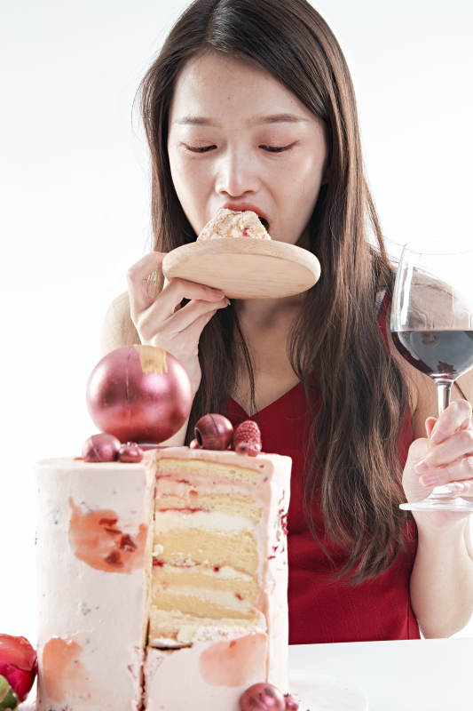 喝红酒品尝蛋糕的年轻女性图片