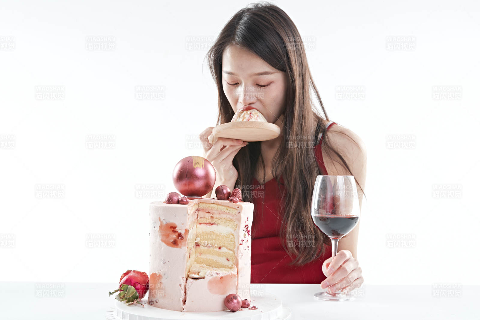 喝红酒品尝蛋糕的年轻女性图片