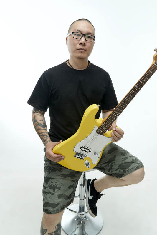 手持电吉他展示演奏的亚洲男性摇滚乐手人像图片