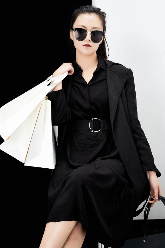 黑白色背景下的手提购物袋的时尚亚洲少女图片