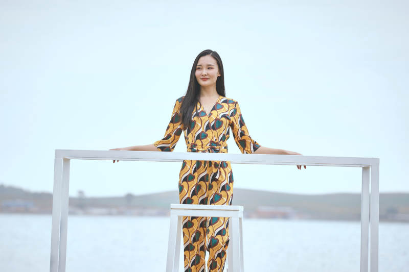 悠闲的坐在美丽湖岸码头的亚洲年轻女性人像图片