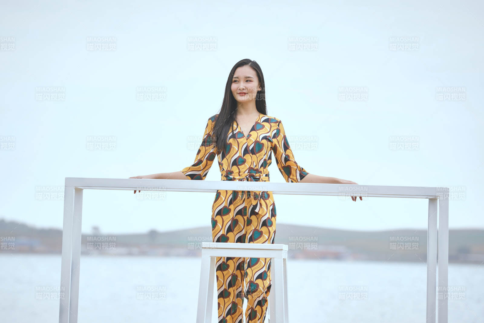 悠闲的坐在美丽湖岸码头的亚洲年轻女性人像图片