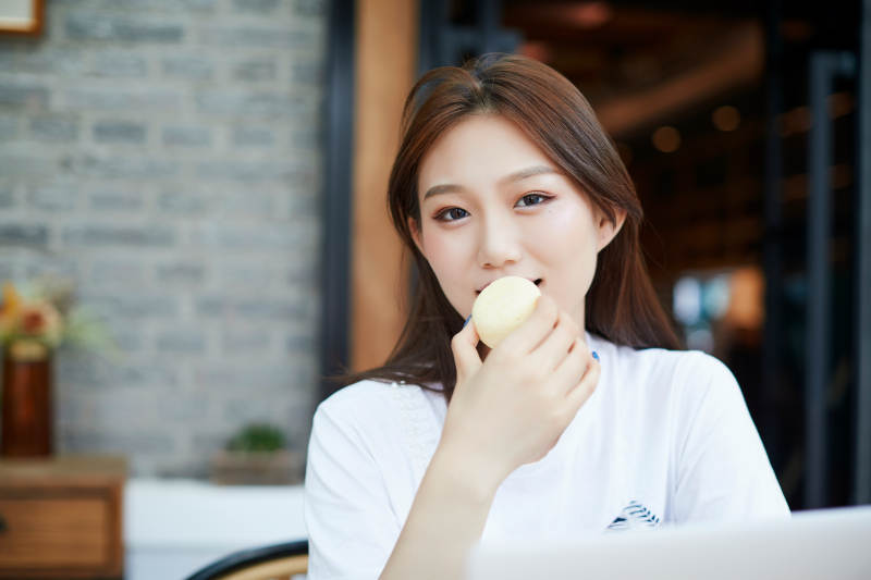 坐在咖啡图书馆吃东西的可爱少女图片