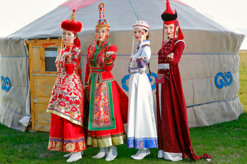 草原上穿着蒙古族传统服饰的亚洲年轻美少女图片