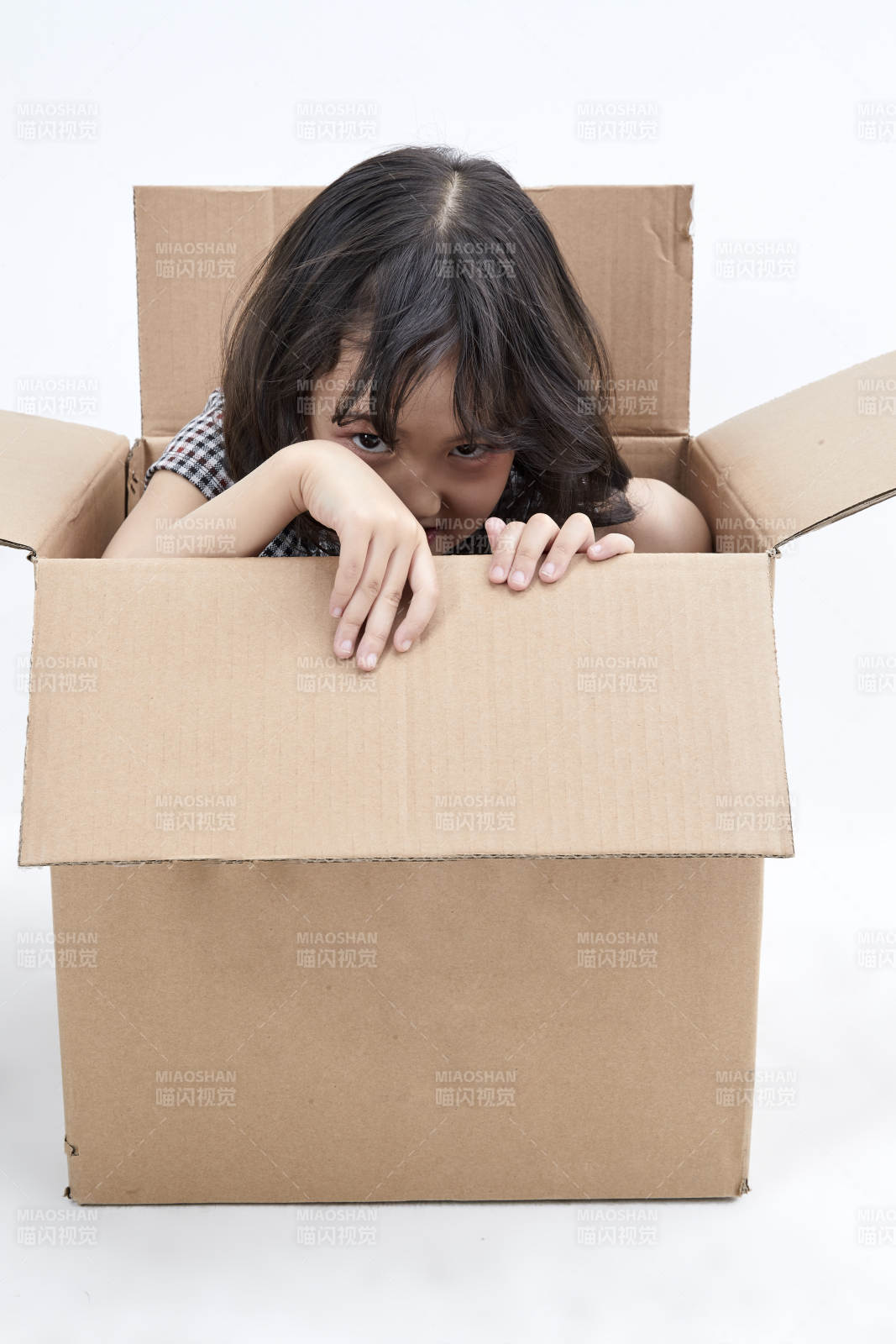 躲在纸箱中玩耍的调皮可爱亚洲小女孩儿童图片