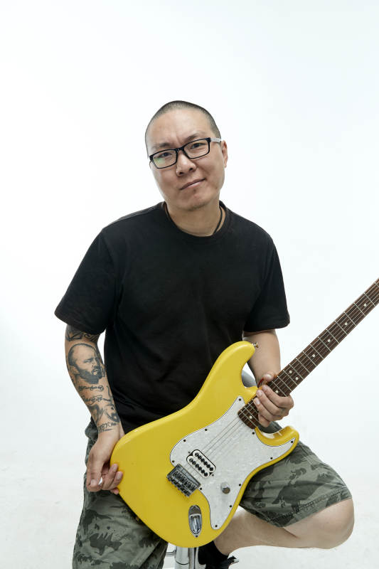 手持电吉他展示演奏的亚洲男性摇滚乐手人像图片