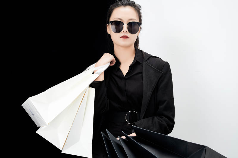 黑白色背景下的手提购物袋的时尚亚洲少女图片
