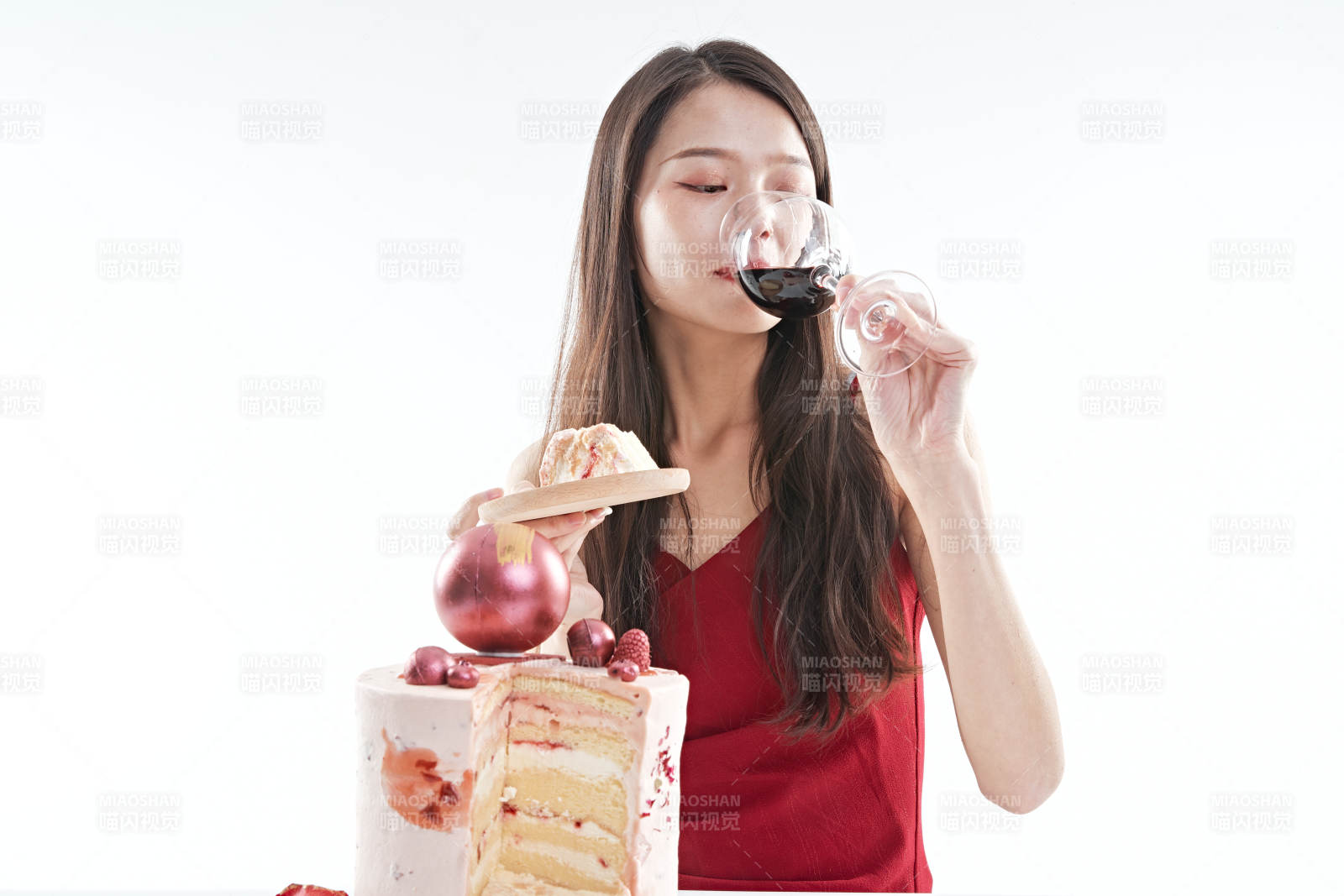 喝红酒品尝蛋糕的年轻女性图片