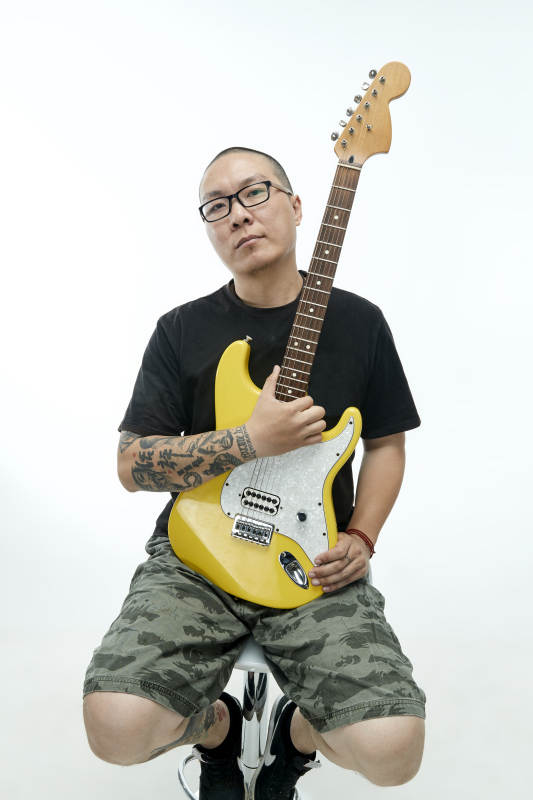 手持电吉他展示演奏的亚洲男性摇滚乐手人像图片