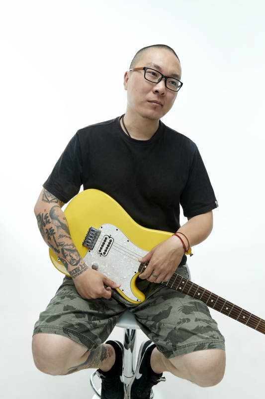 手持电吉他展示演奏的亚洲男性摇滚乐手人像图片