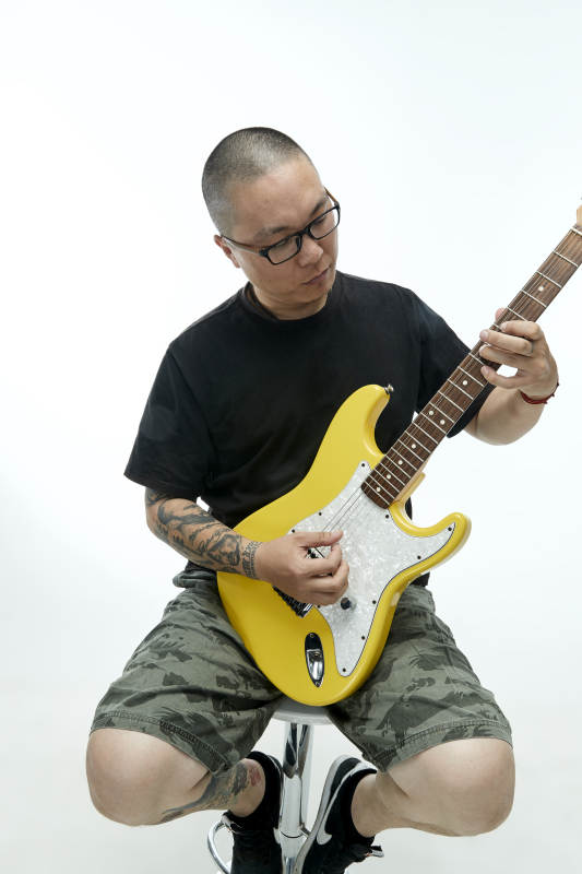 手持电吉他展示演奏的亚洲男性摇滚乐手人像图片