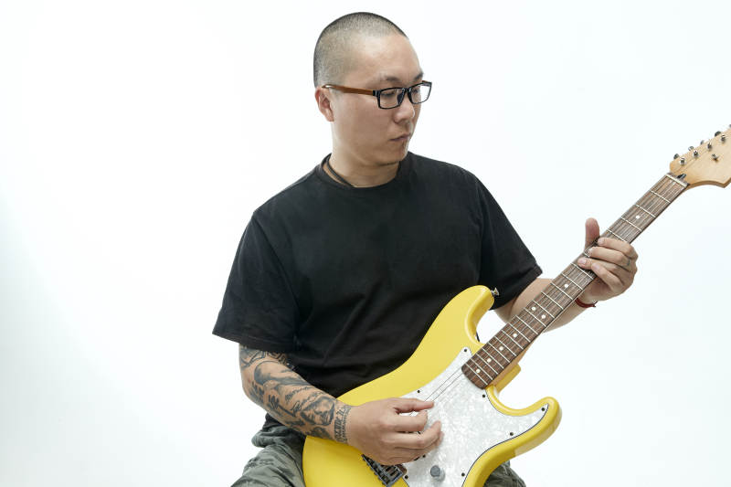 手持电吉他展示演奏的亚洲男性摇滚乐手人像图片