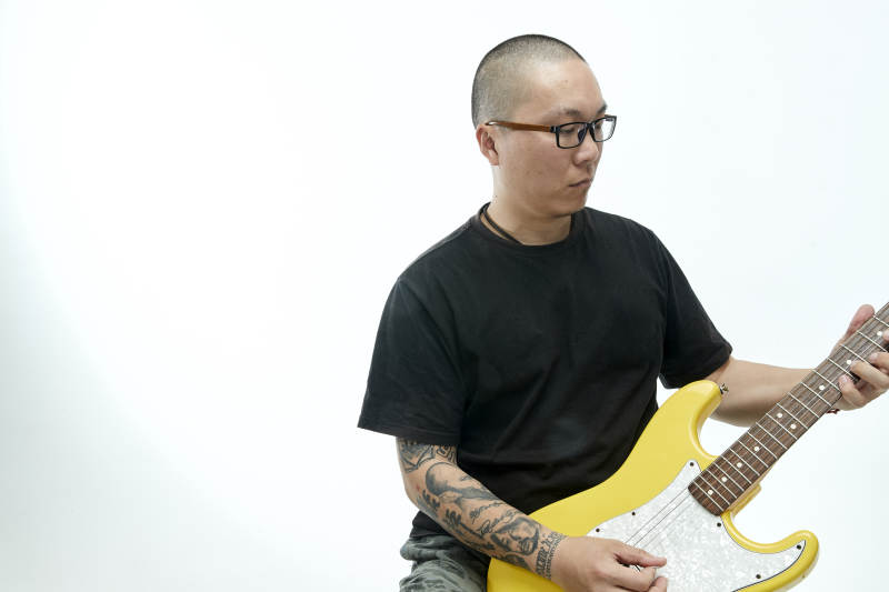 手持电吉他展示演奏的亚洲男性摇滚乐手人像图片