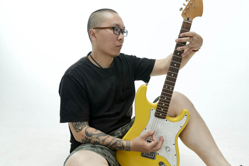 手持电吉他展示演奏的亚洲男性摇滚乐手人像图片