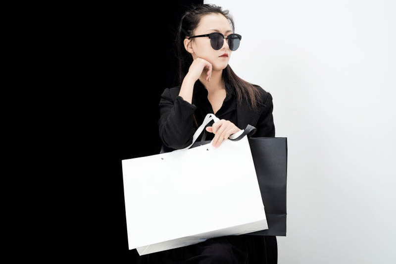 黑白色背景下的手提购物袋的时尚亚洲少女图片